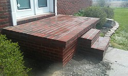 Porch was covered in tile. Removed tile and set thin brick instead